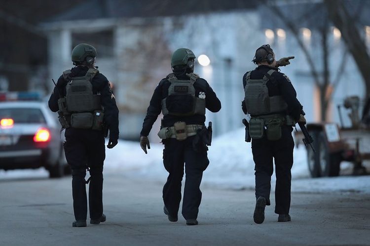 Petugas kepolisian mengamankan area sekitar lokasi penembakan di Aurora, Illinois, Jumat (15/2/2019).