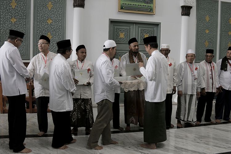 Presiden Joko Widodo menyerahkan sertifikat tanah wakaf untuk Masjid, Menasah dan Pesantren Di Aceh secara simbolis kepada 12 orang perwakilan usai melaksanakan shalat Jumat (14/12/2018) di Masjid Raya Baiturrahman, Banda Aceh, Jumat (14/12/2018). 