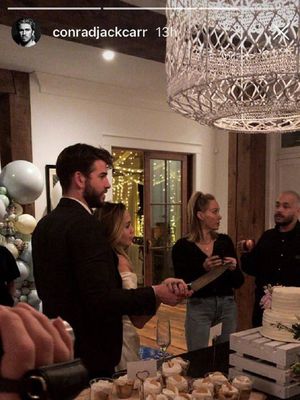 Pasangan Miley Cyrus dan Liam Hemsworth dikabarkan sedang memotong kue pernikahan mereka.