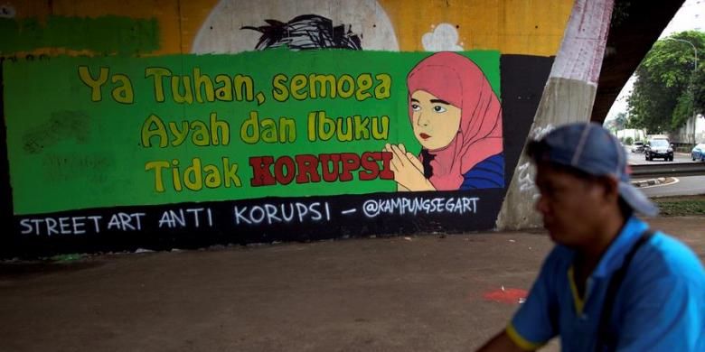 Penjual minuman keliling melintas didepan mural berisi kritikan terhadap koruptor di Jalan Gatot Subroto, Jakarta Selatan, Rabu (12/12/2012). Kritikan terhadap pelaku koruptor terus disuarakan oleh aktivis untuk mendorong tindakan lebih tegas dalam pemberantasan korupsi dan penegakan hukum lainnya.
