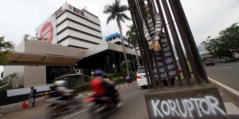 Aktivis anti korupsi memasukan boneka koruptor ke dalam tiang pancang dan diborgol di depan Gedung Komisi Pemberantasan Korupsi, Jakarta, Rabu (12/12/2012). Pemasangan boneka koruptor tersebut ditujukan sebagai peringatan kepada para koruptor, dalam rangka Hari Anti Korupsi.  