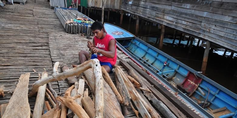 Salah seorang warga bajo di Desa Hakatutobu yang sedang membelah kayu bakar.