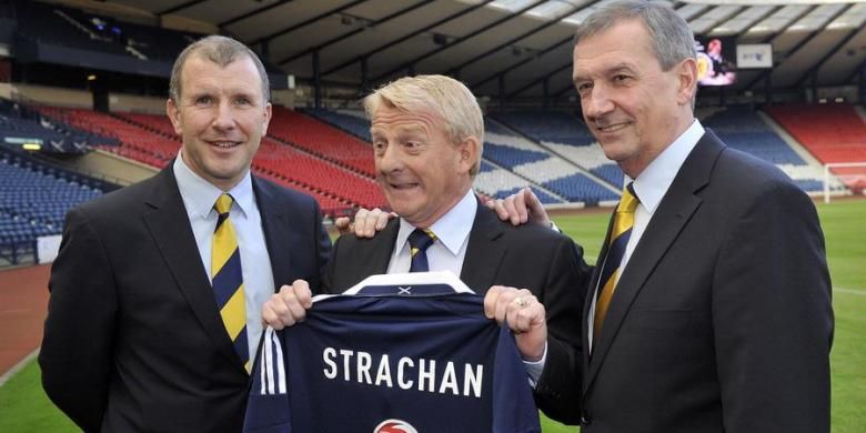 Pelatih timnas Skotlandia yang baru terpilih, Gordon Strachan (tengah), berpose dengan kostum timnas yang bertuliskan namanya, di samping Stewart Regan (kiri), Chief Executive Asosiasi Sepak Bola Skotlandia (SFA), dan Campbell Ogilvie, Presiden SFA, setelah konferensi pers di Glasgow, Selasa (15/1/2013). 