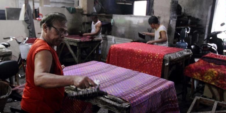 Para perajin menyelesaikan pembuatan batik cap di salah satu workshop toko batik di kawasan Kampung Batik Laweyan, Kota Solo, Rabu (9/4/2013). Sebagai sentra batik tertua di Solo dan kawasan heritage, Laweyan menjadi salah satu tujuan wisatawan bila mengunjungi kota ini.
