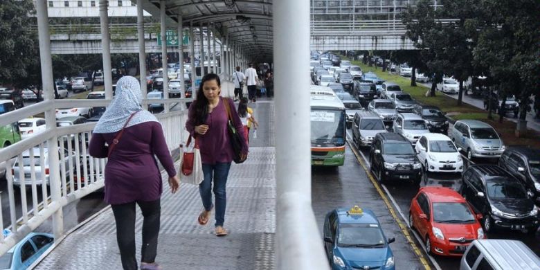 Penumpang berjalan di jembatan penyeberangan usai sampai di Halte Dukuh Atas, Jakarta Selatan, Kamis (11/4/2013). Pembenahan sarana angkutan umum mendesak dilakukan untuk mencegah lalu lintas Jakarta macet total.