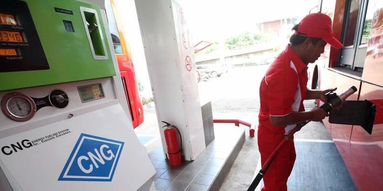 Petugas mengisi bahan bakar gas (BBG) jenis gas alam terkompresi (compresed natural gas/CNG) ke bus Transjakarta