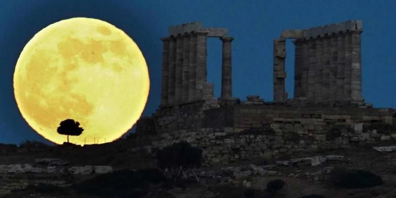 Bulan purnama naik di sebelah kuil Yunani kuno Poseidon di Cape Sounion, sekitar 65 kilometer selatan Athena, 23 Juni 2013. Bulan yang akan mencapai tahap penuh pada Minggu, 14 persen lebih dekat ke bumi dan dikenal sebagai fenomena supermoon.