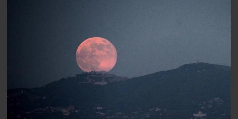 Bulan purnama terbit di atas kota Roma, 23 Juni 2013. Bulan yang akan mencapai tahap penuh pada Minggu, 14 persen lebih dekat ke bumi dan dikenal sebagai fenomena supermoon.