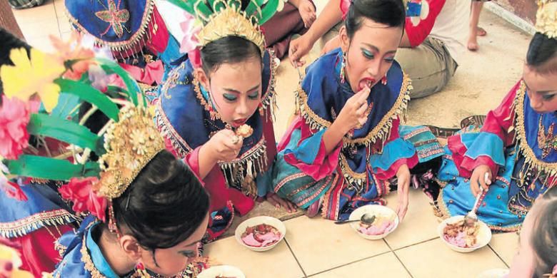 Para penari tari Lenggang Nyai menikmati bubur ase sebelum mengiringi sebuah pesta pernikahan di kawasan Senayan, Jakarta, Mei 2013. Bubur ase, makanan khas Betawi yang sudah langka, merupakan campuran dari bubur ayam, asinan sawi, dan semur. 