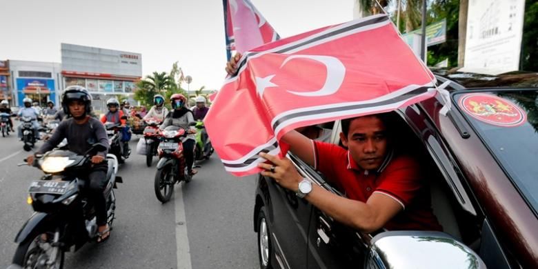 Warga dari Kabupaten Nagan Raya konvoi sambil mengibarkan Bendera Bintang Bulan di seputaran Kota Banda Aceh, Selasa (26/3/2013). Sejak 25 Maret 2013, Pemerintah Aceh telah menetapkan dan mengundangkan dalam lembaran daerah bendera dan lambang Gerakan Aceh Merdeka (GAM) sebagai lambang dan bendera daerah.  