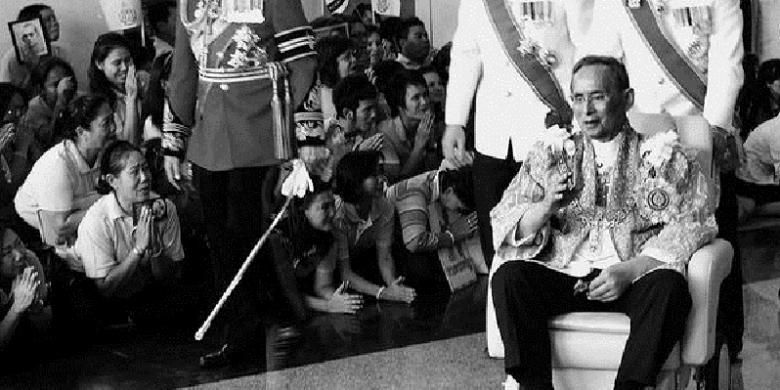 Raja Thailand Bhumibol Adulyadej yang duduk di kursi roda membalas sambutan warga yang menunggunya saat kembali ke Rumah Sakit Siriraj dari Istana Agung di Bangkok, Thailand, tempat dia memberikan sambutan dalam perayaan ulang tahunnya yang ke-84, Senin (5/12/2011).