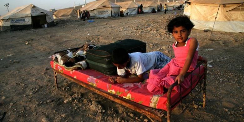 Dua orang pengungsi anak-anak Suriah, bermain di sebuah kamp pengungsi Suriah di dekat kota Arbil, Irak. PBB mengatakan sekitar satu juta anak-anak Suriah kini menjadi pengungsi di berbagai negara dan dua juta lainnya kehilangan tempat tinggal.
