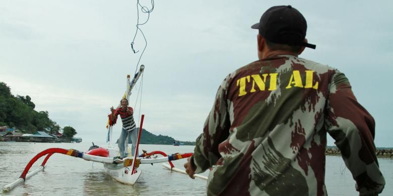 Effendi Soleman sedang melempar tali tambat kepada seorang anggota TNI AL, sesaat setelah dirinya berlabuh di pelabuhan Tanjung Batu Pemangkat, Kabupaten Sambas, Kalimantan Barat (6/9/2013)