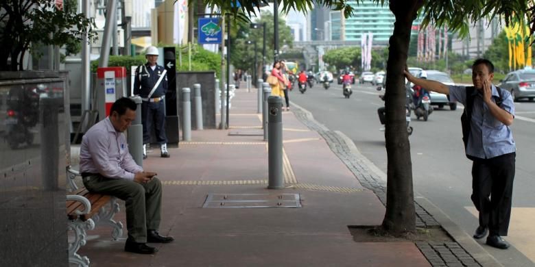 Warga duduk di bangku taman yang terpasang sejak semalam di kawasan Jalan MH Thamrin, Jakarta, Rabu (19/6/2013). Sebanyak 340 unit bangku taman dipasang di Jalan Sudirman, Jalan MH Thamrin hingga kawasan Medan Merdeka untuk memberikan kenyamanan kepada pengguna trotoar di Jakarta.