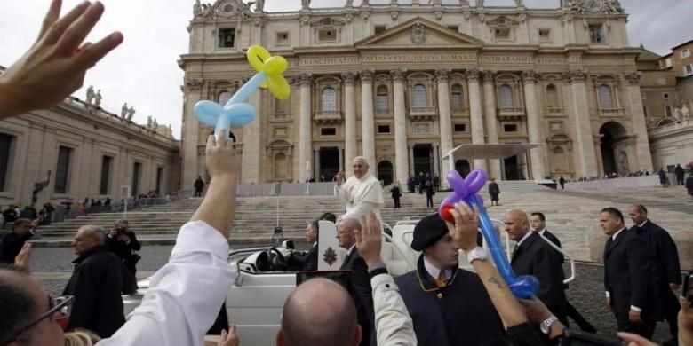 Paus Fransiskus membalas sapaan umat saat dia meninggalkan Alun-alun St Peter usai pertemuan umum mingguan di Vatikan, 9 Oktober 2013.