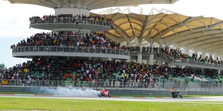 Pebalap Ducati asal Amerika Serikat, Nicky Hayden (belakang) memacu motornya yang mengeluarkan asap di Sirkuit Sepang, pada GP Malaysia, Minggu (13/10/2013).