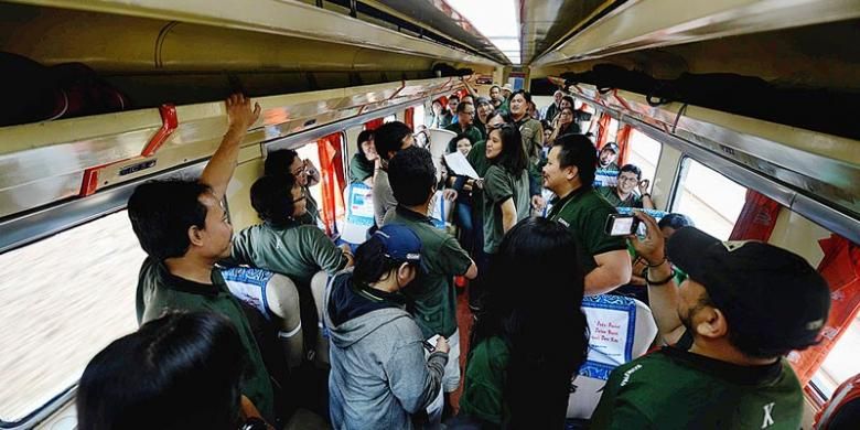 Para penumpang wisata saat bermain kuis di dalam gerbong KA Cirebon Ekspress dari Jakarta menuju Cirebon, Sabtu (7/12/2013). Berwisata dengan kereta api makin diminati karena tepat waktu dan perjalanan tidak terhadang kemacetan.