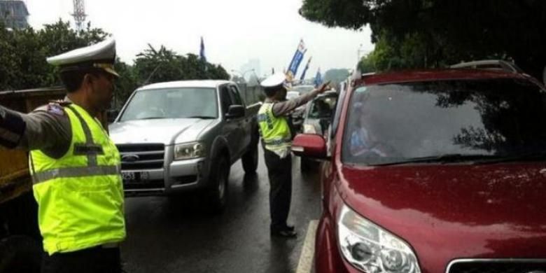 Polisi mengarahkan mobil yang hendak melintas di Jalan TB Simatupang untuk masuk jalan tol.
