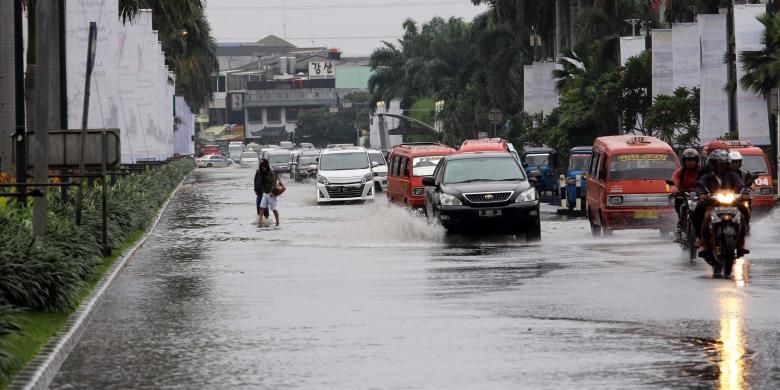 Pengendara melintasi genangan di Jalan boulevard, Kelapa Gading  Jakarta Utara, Jumat (17/1/2014). Hujan lebat mengguyur Jakarta sejak pagi, membuat sejumlah jalanan Ibukota tergenang. 