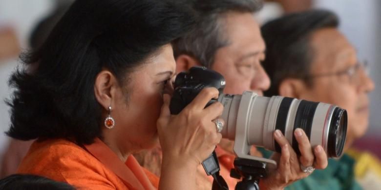 Ibu Negara Ani Yudhoyono memotret dengan kamera DSLR disamping Presiden Susilo Bambang Yudhoyono (tengah) dan Wakil Presiden Boediono (kanan) saat parada Hari Kemerdekaan di Jakarta, 18 Agustus 2013. AFP PHOTO / ADEK BERRY / FILES