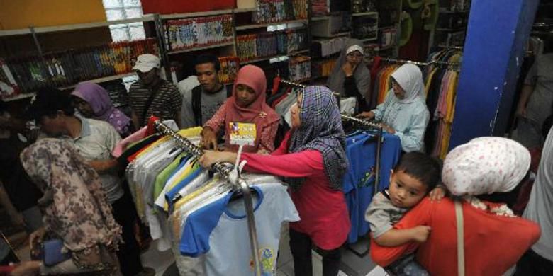 Pemudik berbelanja kaos di gerai industri kaos Dagadu, Jalan Pakuningratan, Yogyakarta, Jumat (24/8/2012). Kaos hasil industri kreatif merupakan salah satu komoditi yang banyak dicari pemudik selama berada di Yogyakarta. 