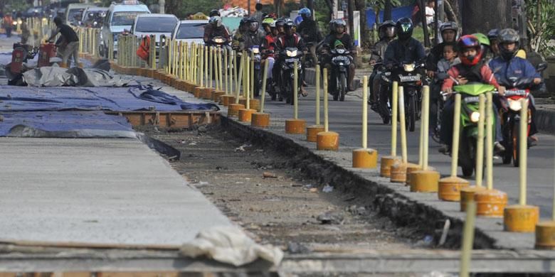 Pengerjaan proyek jalan beton di Jalan Mayjend DI Panjaitan, Jakarta Timur, Minggu (3/6/2012). Jalan dibeton karena konstruksi jalan lama dari aspal mudah rusak akibat beban berat kendaraan yang melintas. 