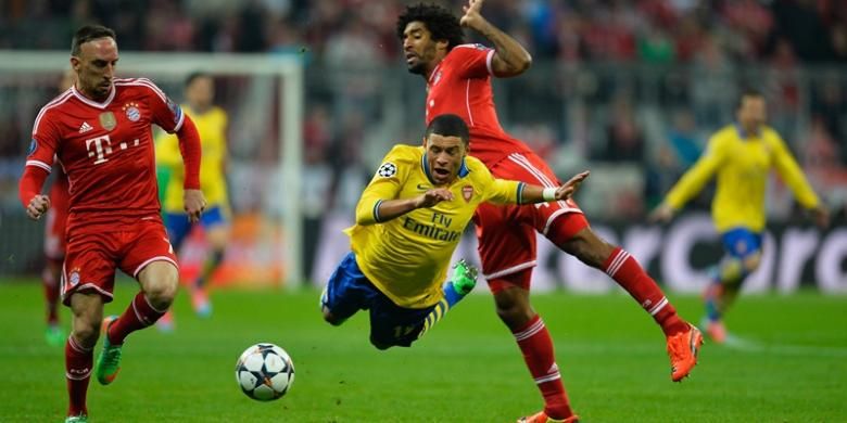 Gelandang Arsenal, Alex Oxlade-Chamberlain, terjatuh dalam pertandingan leg kedua babak 16 besar Liga Champions melawan Bayern Muenchen di Allianz Arena, Selasa (11/3/2014). 