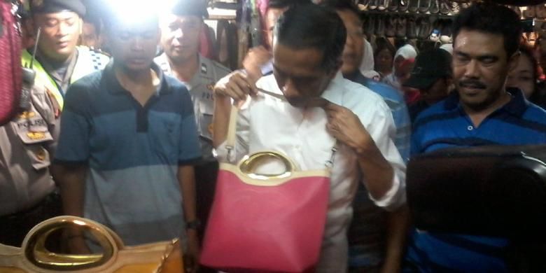 Bakal calon presiden PDI Perjuangan, Joko Widodo (tengah), melihat tas sebelum membelinya saat berkampanye di Pasar Ramayana, Cianjur, Jawa Barat, Sabtu (29/3/2014) siang.