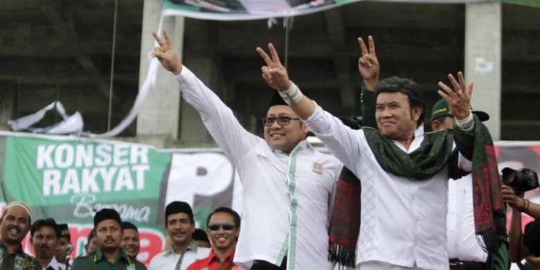 Ketua Umum Partai Kebangkitan Bangsa Muhaimin Iskandar bersama raja dangdut Rhoma Irama, menyapa para pendukung Partai PKB saat pembukaan kampaye perdana partai tersebut di halaman Gedung Islamic Center Lampeuneurut, Aceh Besar, 16 Maret 2014.