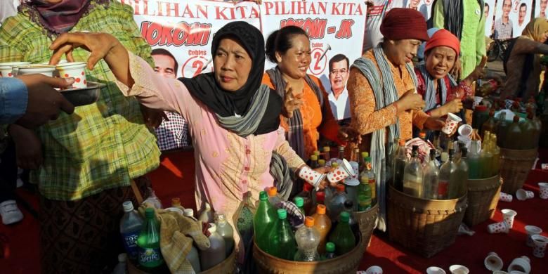 Penjual jamu gendong memberikan jamu gratis kepada warga yang sedang menikmati car free day di sekitar bundaran HI Jakarta Pusat, Minggu (8/6/2014). Penjual jamu ini memberikan jamu gratis sebagai ungkapan dukungannya kepada pasangan Jokowi-JK.