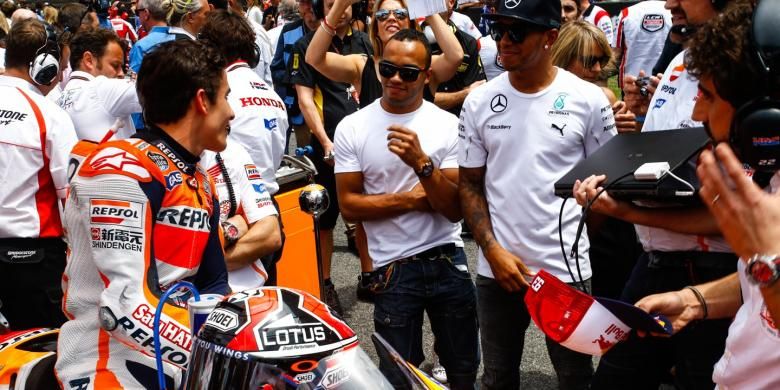 Pebalap Repsol Honda asal Spanyol, Marc Marquez (kiri), berbicara dengan pebalap Formula 1 asal Inggris, Lewis Hamilton (tengah), jelang start GP Catalunya, Minggu (15/6/2014).