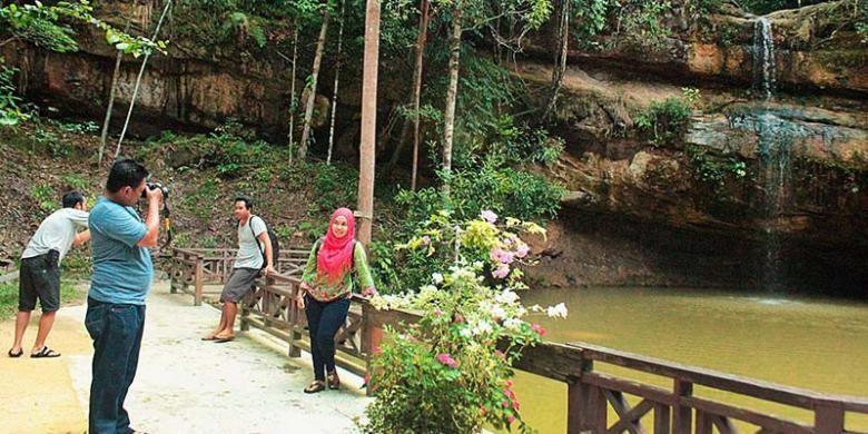 Pengunjung mengabadikan diri dengan kamera di tempat wisata Air Terjun Batu Mahasur, Kuala Kurun, Kabupaten Gunung Mas. Tempat wisata itu berada di kawasan lindung seluas 100 hektar yang dikelola dinas kehutanan.