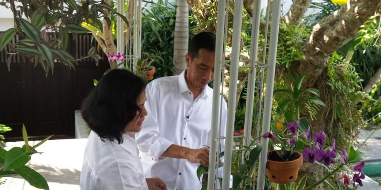 Joko Widodo dan Iriana mengurus anggrek di halaman belakang rumahnya di Solo, Jawa Tengah.

