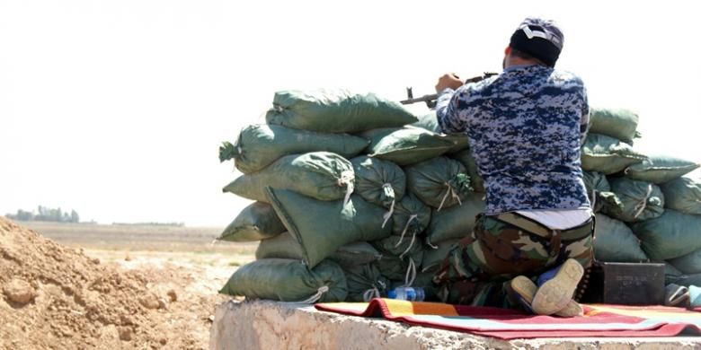 Seorang pejuang milisi pro-pemerintah Irak tengah siaga di kota Taza Khurmatu, yang terletak di sebelah selatan kota Kirkuk. Militer Irak berharap serangan udara AS terhadap posisi ISIS bisa mengubah situasi di medan perang.