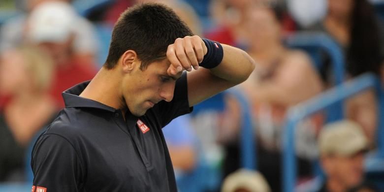 Petenis Serbia, Novak Djokovic mengelap keringat ketika menjalani laga babak kedua Western & Southern Open melawan petenis Perancis, Gilles Simon, di Cincinnati, Selasa (12/8/2014). Djokovic menang 6-3, 4-6, 6-4.