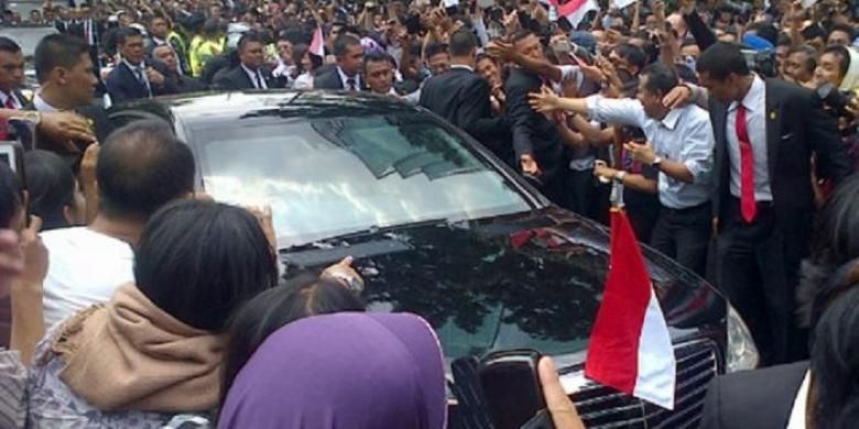 Massa mendekati mobil RI 1 yang ditumpangi Presiden Joko Widodo di Jalan Sudirman, Jakarta Pusat, Senin (20/10/2014). 