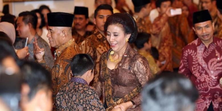 Menteri Kelautan dan Perikanan Susi Pudjiastuti berbicara dengan cucunya sebelum melakukan sumpah jabatan menteri di Istana Negara, Jakarta, Senin (27/10/2014).