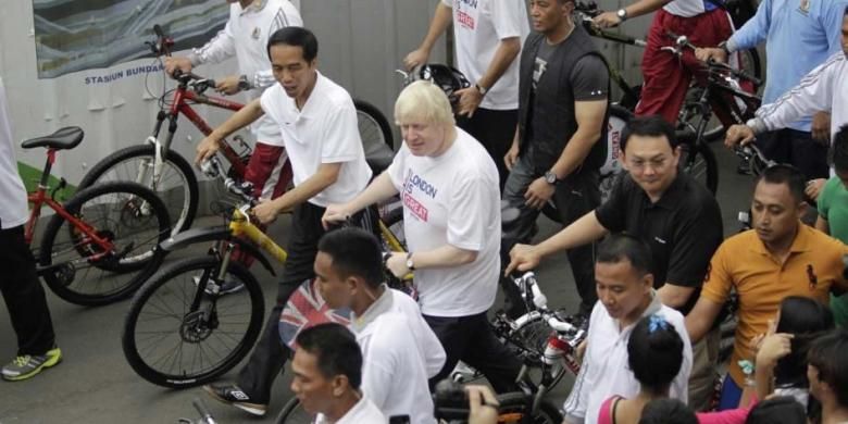 Presiden Joko Widodo (kiri) didampingi oleh Gubernur DKI Jakarta Basuki Tjahaja Purnama dan Wali Kota London Boris Johnson (tengah) menuntun sepeda saat car free day, di kawasan Bundaran Hotel Indonesia, Jakarta, Minggu (30/11/2014). Sebelum bersepeda Jokowi juga sempat menyaksikan penyerahan sepeda secara simbolis dari Pemerintah Kota London kepada Pemerintah Provinsi DKI Jakarta.