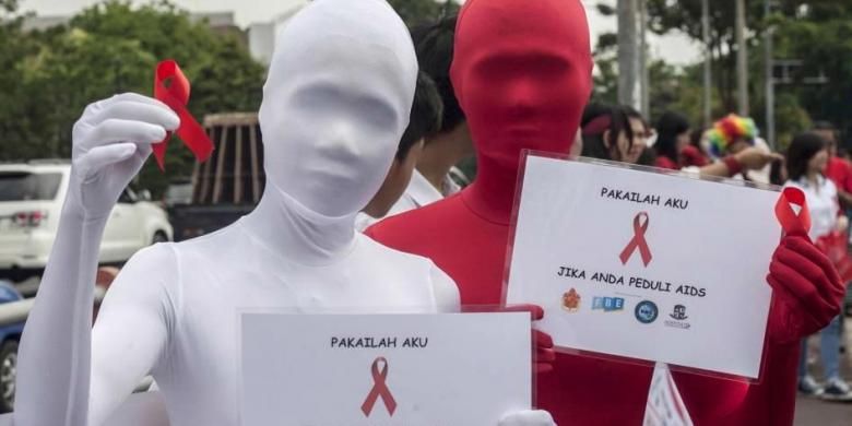 Aktivis membawa pita merah dalam kampanye Hari AIDS Sedunia, di Surabaya, Senin (1/12/2014). Sekitar 45.000 kasus HIV/AIDS terjadi di Indonesia sepanjang 2013 dan 14.400 kematian di tahun yang sama.