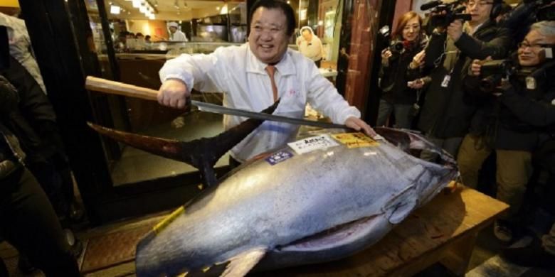 Kiyoshi Kimura, Presiden Kiyomura KK, berpose dengan ikan tuna seberat 180 kilogram, yang dibeli seharga 4,51 juta yen dalam lelang tahun baru tahunan di pasar ikan Tsukiji, Tokyo, Senin (5/1/2015).