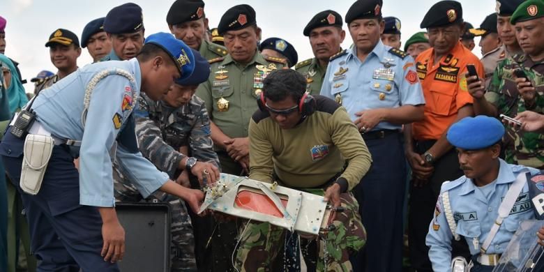Para petugas memasukkan FDR (Flight Data Recorder) AirAsia QZ8501 ke dalam tas pengaman di Pangkalan Bun, Senin (12/1/2015).