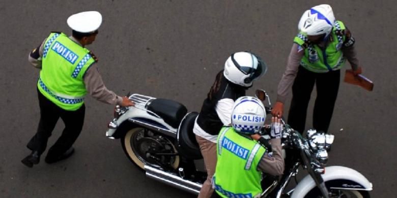 Seorang pengendara Harley Davidson bernomor polisi B 6168 ESG untuk ditilang karena melintasi Jalan MH Thamrin, Jakarta Pusat, yang merupakan kawasan terlarang sepeda motor, Minggu (18/1/2015).