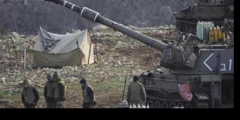 Tentara Israel berdiri dekat unit artileri bergerak di Dataran Tinggi Golan dekat perbatasan dengan Suriah (28/1). 