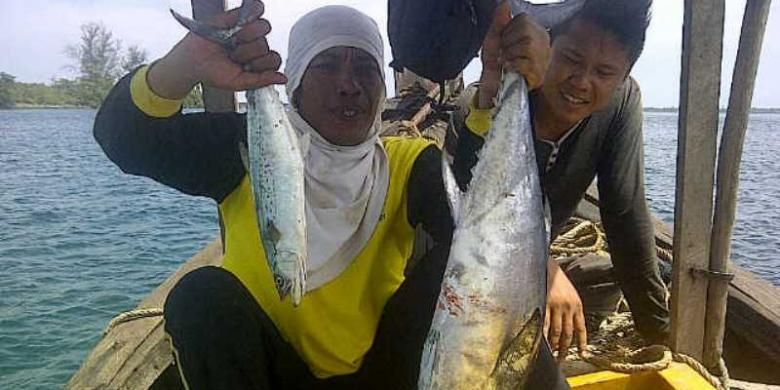 Pemancing memamerkan hasil tangkapan tuna dan tenggiri