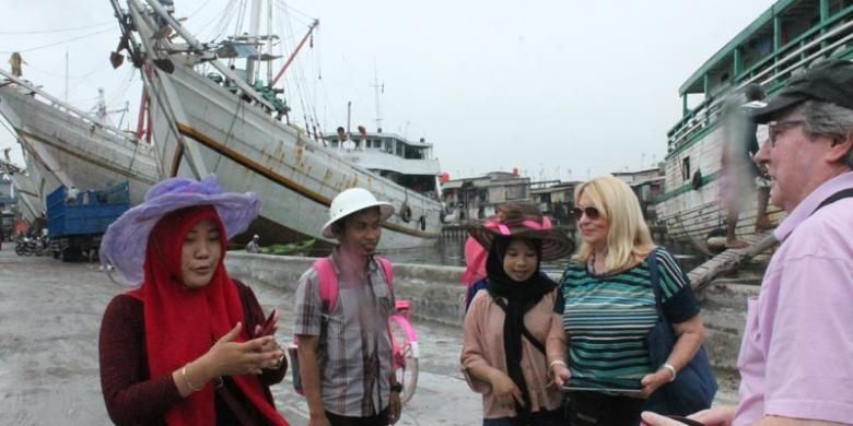 Turis kapal pesiar MS Rotterdam berbincang-bincang dengan penduduk di Pelabuhan Sunda Kelapa, Jakarta, Kamis (19/2/2015).