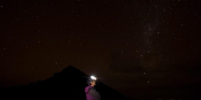 Sejumlah benda langit menarik teramati dari puncak Tambora pada Senin (23/3/2015). Bagian yang tampak seperti selendang adalah Bimasakti. Di bawahnya, ada dua titik terang, menunjukkan Alpha dan Beta Centauri. Tiga titik yang membentuk bangu segitiga dengan puncak terbalik adalah rasi Gubug Penceng. 