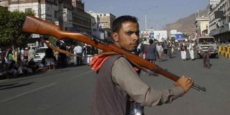 Pemberontak Houthi Syiah membawa senjata saat ia bergabung dalam aksi protes terhadap serangan udara Saudi Arabia, di Sanaa, Yaman, 1 April 2015.