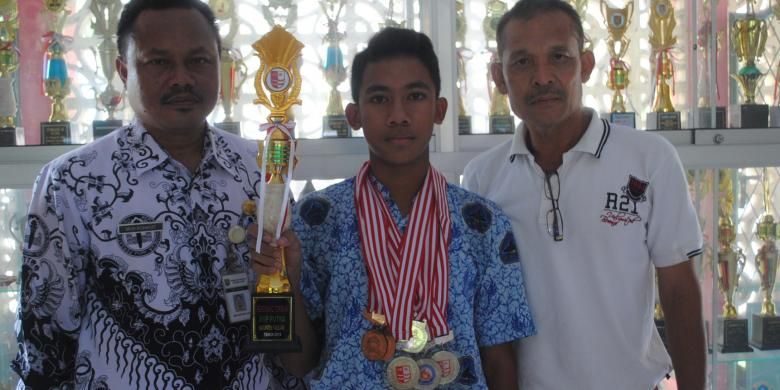 Risky Cahyo Raharjo (15) (tengah) siswa SMP Negeri Kota Mungkid, Kabupaten Magelang yang berprestasi di bidang cabang olahraga renang.