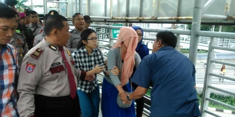 Petugas keamanan dari kepolisian dan TNI berupaya membujuk turun perempuan muda yang diduga hendak loncat dari JPO Kuningan Madya, Kuningan, Jakarta Selatan, Jumat (24/4/2015)