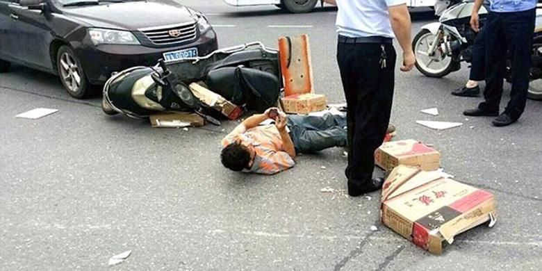 Pria Tiongkok di kota Changsa sibuk dengan ponselnya sambil terkapar di tengah jalan usai mengalami kecelakaan
